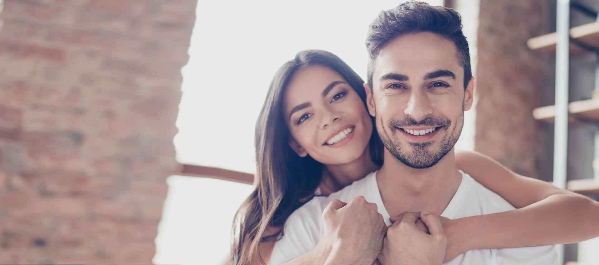 Joyful couple with perfect smiles with a softly blurred background emphasizes the positive outcome of dental care and health.