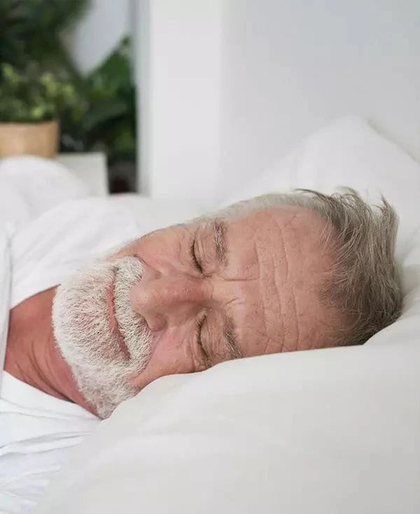 A tranquil and well-rested man peacefully sleeping, enjoying freedom from sleep apnea.